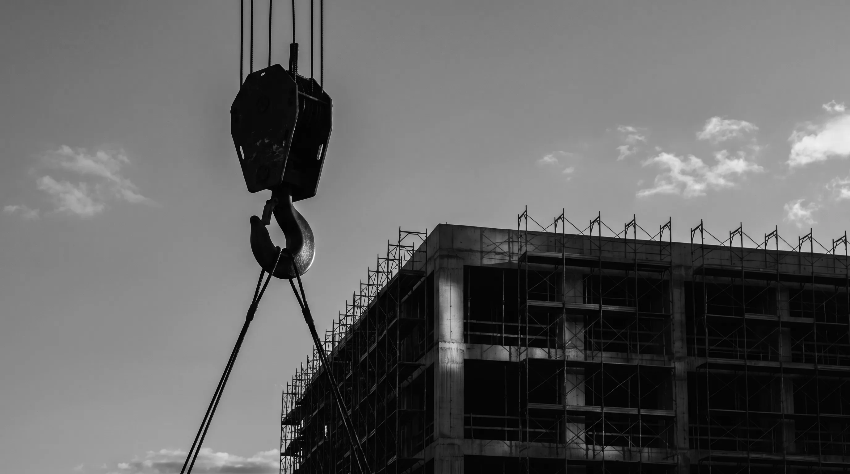 A rising structure at dusk, representing ground-up development built for lasting quality