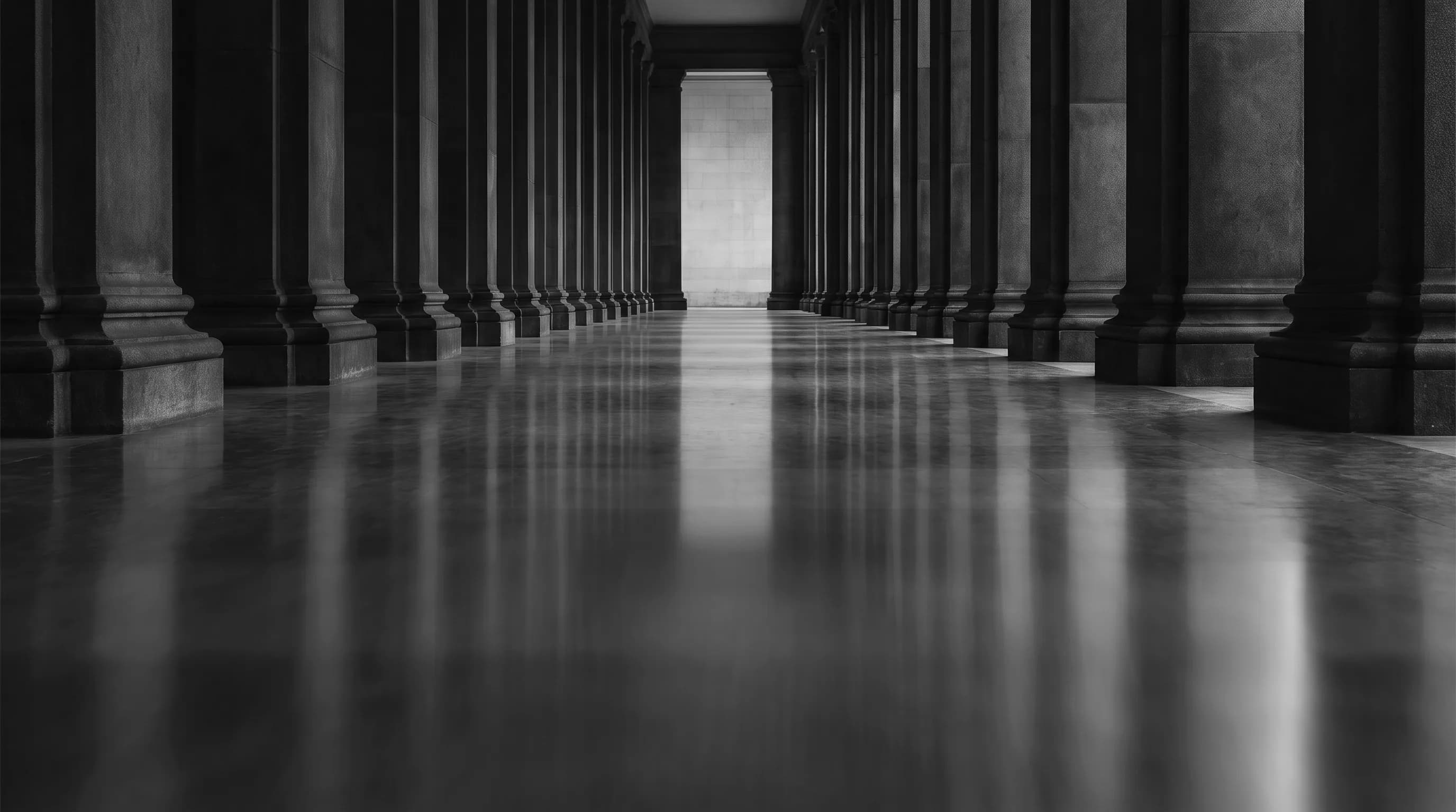 A stone colonnade receding toward warm light, evoking permanence and discipline